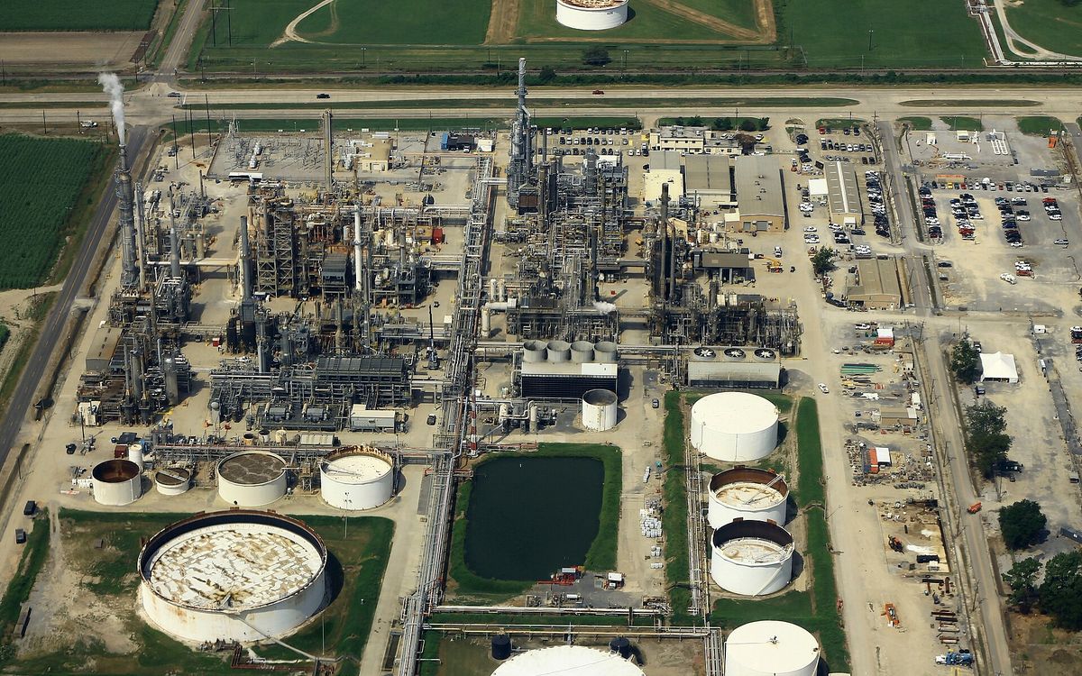 Aerial view looking down on an oil refinery, with storage tanks, pipework and process units