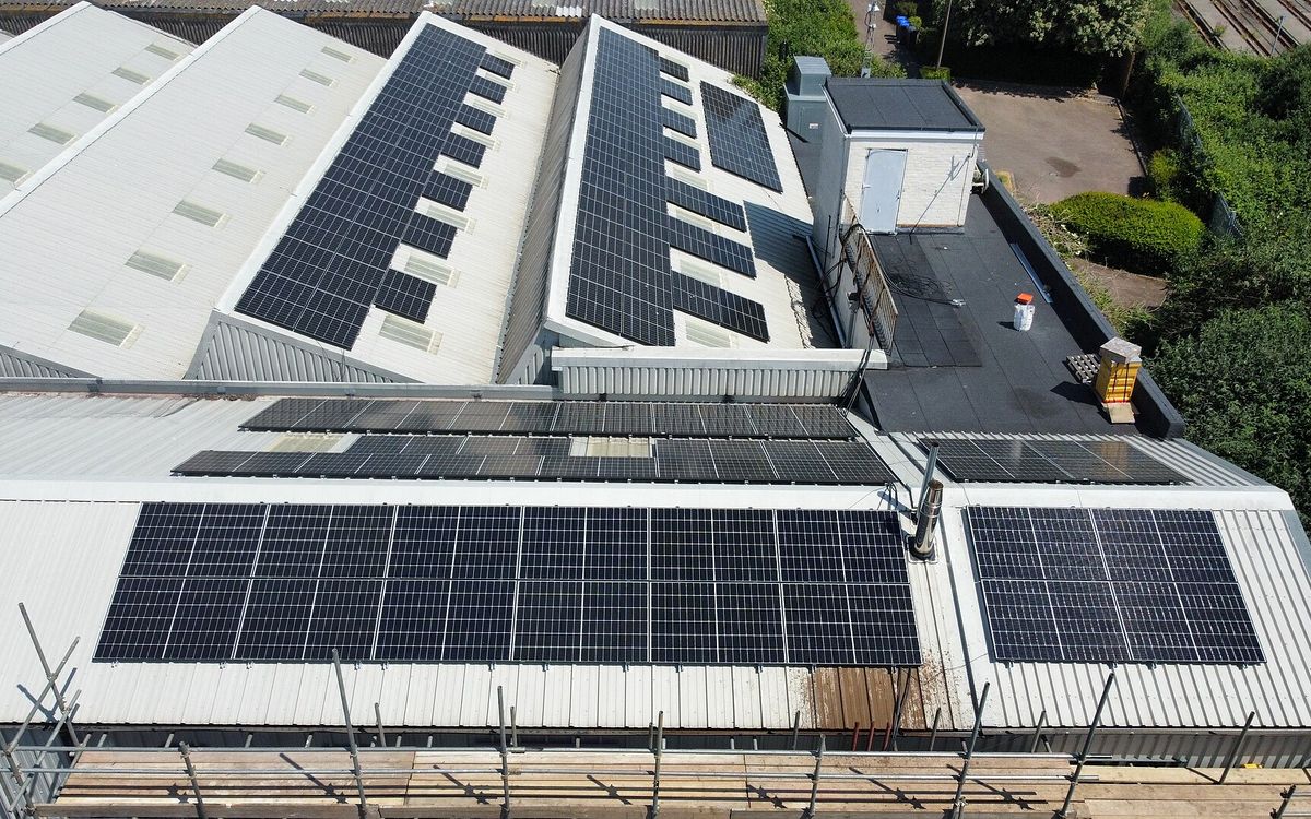Drone view of a large commercial roof covered in solar panels