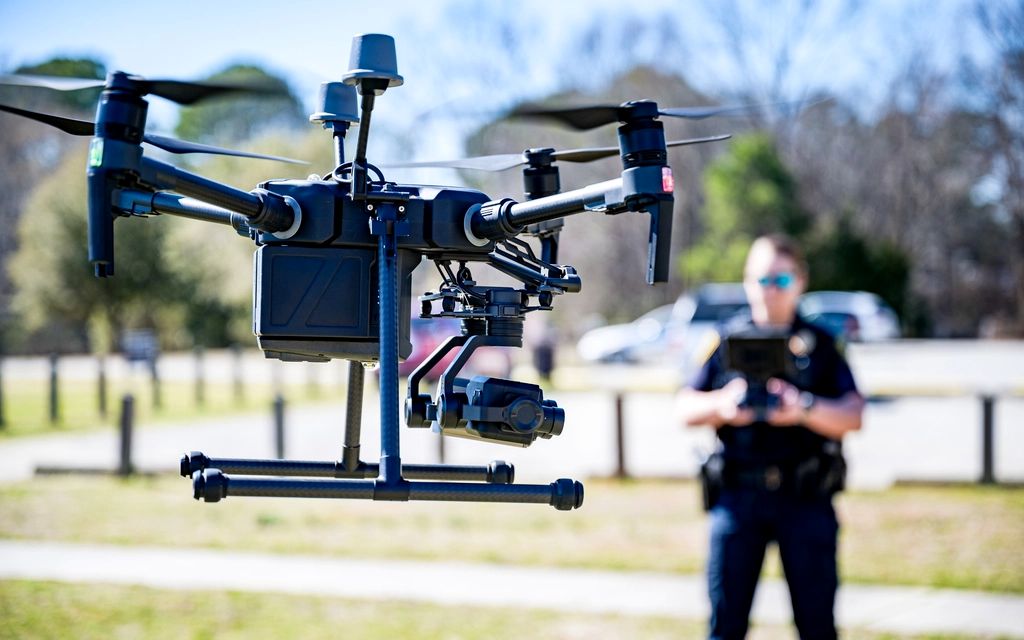 A police officer with a tablet controller flying an enterprise drone with a stabilized camera gimbal